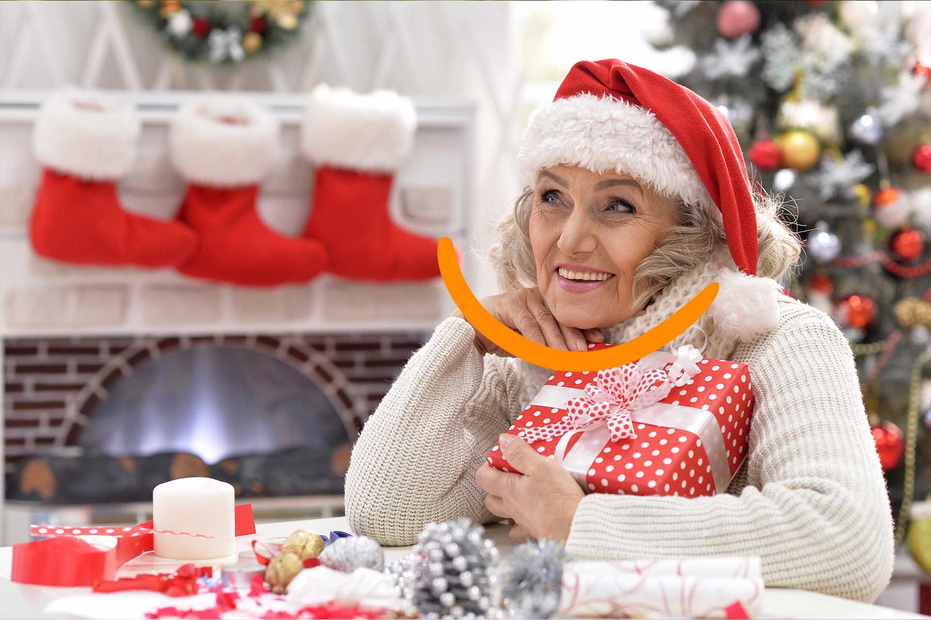 femme senior qui sourit devant un cadeau de Noël